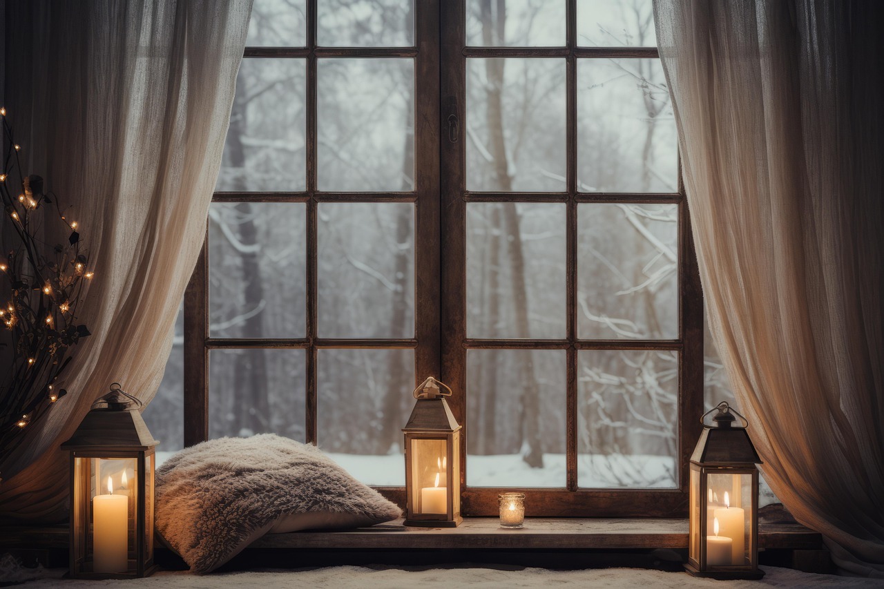 Warmly lit window with glowing candles and soft pillows on the windowsill, snow-covered trees visible outside, creating a peaceful and inviting indoor atmosphere